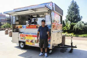 Photo by Amanda Goldstein A worker of Shah's Halal Food stands in front of a new dining option for Queens College students.