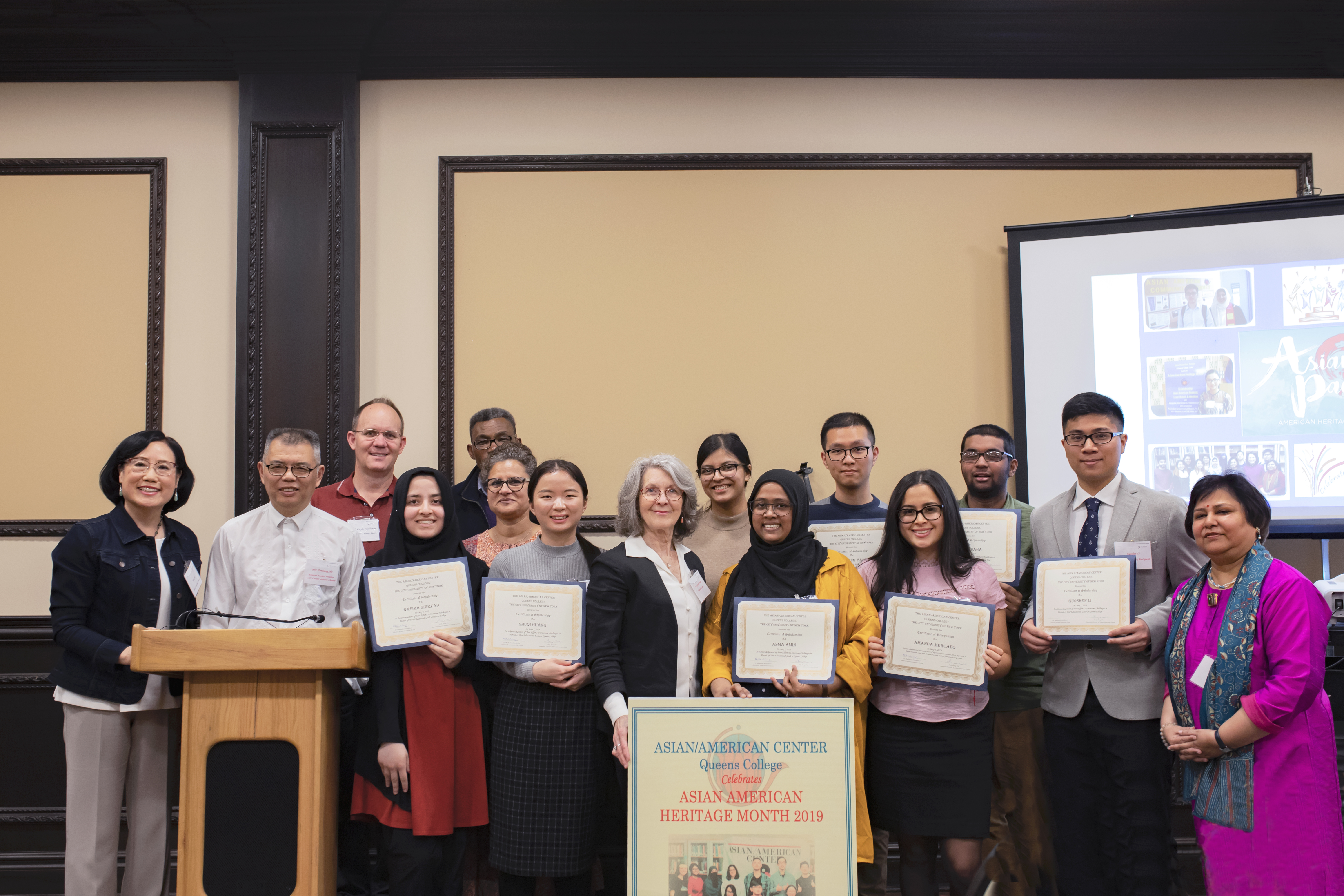 Credit: Asian-American Center Caption: Scholarship recipients pose with their scholarships, along with the Directors of the Asian-American Center.